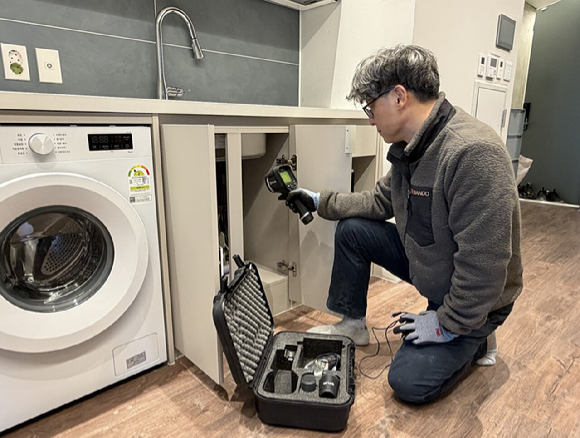 반도건설 관계자가 반도 유보라 아파트 입주 세대를 방문, 열화상카메라를 이용해 단열상태를 점검하고 있다. [사진=반도건설]