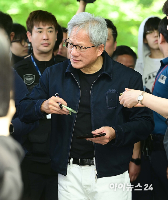 젠슨 황 엔비디아 최고경영자(CEO)가 5일 오후 전세기를 통해 서울김포비즈니스항공센터로 입국해 시민들의 사인 요청에 응하고 있다. 한 시민이 만원권 지폐에 사인을 요청하자 주머니에 넣을려는 유머스러운 제스쳐을 하며 웃는 젠슨 황의 모습. [사진=정소희 기자]