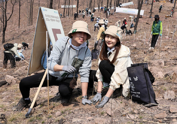 유한킴벌리가 28일 경북 안동 산불피해지에서 '우리강산 푸르게 푸르게 2026 신혼부부 나무심기'를 진행했다. 참가자들이 나무심기에 열중하고 있다. [사진=유한킴벌리]