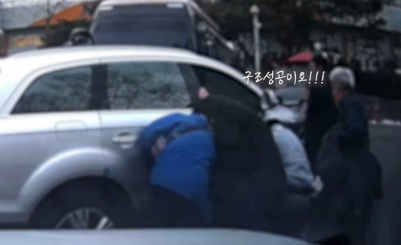 시민들이 차를 들어올리고 있다. [사진=경찰청 유튜브]