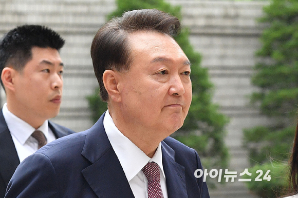 윤석열 전 대통령이 3일 서울 서초구 서울중앙지방법원에서 열린 내란 우두머리 혐의·직권남용 권리행사 방해 혐의 사건 9차 공판에 출석하며 지지자들을 향해 미소를 보이고 있다. [사진=사진공동취재단]