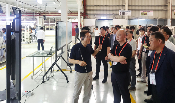 생산성 개선 우수 사례로 꼽힌 LG전자 국내 협력사의 인도 현지 공장을 LG전자와 협력사 임직원들이 함께 둘러보고 있다. [사진=LG전자]