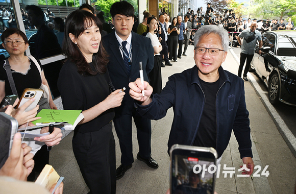 젠슨 황 엔비디아 최고경영자(CEO)가 5일 오후 전세기를 통해 서울김포비즈니스항공센터로 입국해 시민들의 사인 요청에 응하고 있다. 한 시민이 만원권 지폐에 사인을 요청하자 주머니에 넣을려는 유머스러운 제스쳐을 하며 웃는 젠슨 황의 모습. [사진=정소희 기자]