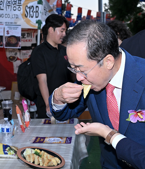 홍준표 대구시장이 LA한인축제 대구식품 공동홍보관에서 대구식품을 시식하고 있다. [사진=대구시]