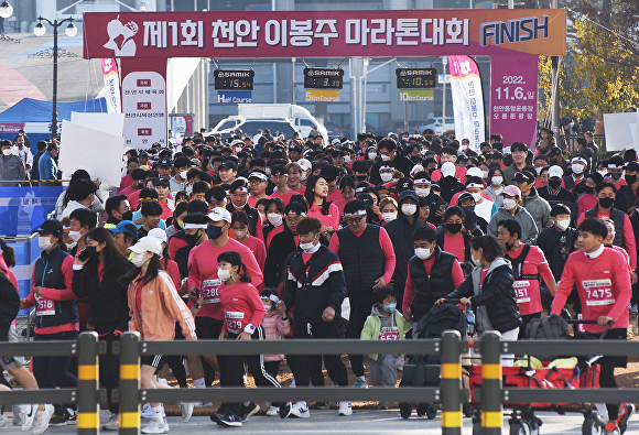 제1회 천안 이봉주 마라톤대회에 출전한 참가자들이 오륜문을 지나 마라톤을 출발하고 있다.  [사진=이숙종 기자]