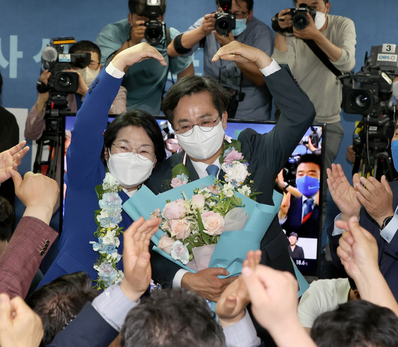 김동연 더불어민주당 경기도지사 당선인이 2일 오전 당선이 확실시되자 경기도 수원시 팔달구 선거사무소에서 꽃다발을 들고 부인 정우영씨와 함께 하트 포즈를 취하고 있다. [사진=뉴시스]