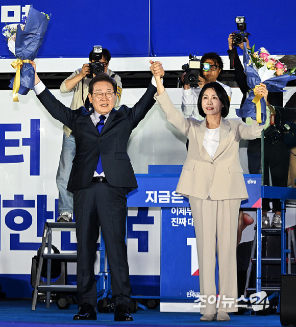 제21대 대통령 당선이 확실시 되는 이재명 더불어민주당 대선 후보가 4일 서울 여의도 국회 정문 앞에 마련된 개표방송 야외무대에서 김혜경 여사와 함께 인사를 하고 있다. [사진=곽영래 기자]
