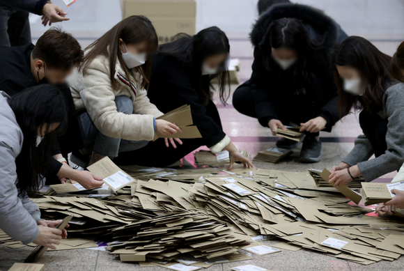 제20대 대통령 선거 사전투표가 끝난 5일 오후 서울역에 설치된 남영동 사전투표소에서 관계자들이 투표함을 열어 관외 투표용지 봉투를 확인하고 있다. 2022.03.05. [사진=뉴시스]