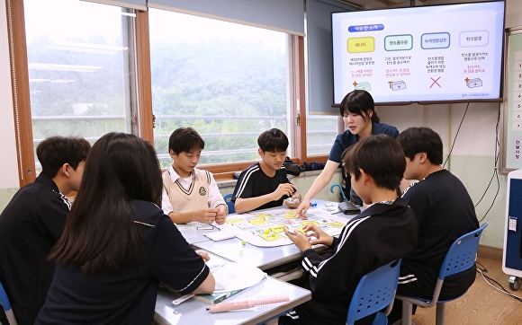 흥덕중학교 1학년 학생들이 단국대 환경교육단 대학생과 함께 환경 교육을 실시하고 신재생에너지 교구를 활용해 게임을 진행하고 있다. [사진=단국대]