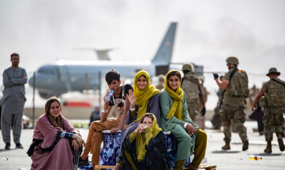 20일(현지시간) 아프가니스탄 카불의 하미드 카르자이 국제공항에서 아프간 어린이들이 가족과 함께 탑승할 비행기를 기다리며 밝게 웃고 있다. [사진=뉴시스 ]