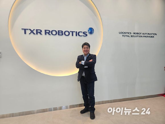 엄인섭 티엑스알로보틱스 대표가 20일 부산 강서구 로봇융합연구소에서 자사의 특수목적 로봇 앞에서 포즈를 취하고 있다. [사진=설재윤 기자]