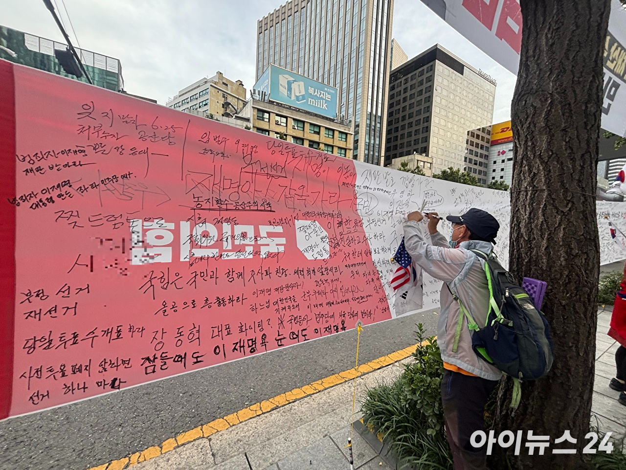 장동혁 국민의힘 대표와 정점식 원내대표를 비롯한 참석 의원들이 3일 서울 중구 숭례문 인근에서 열린 '이재명 정권 심판 민생회복&middot;안보수호 국민행동대회'를 마친 뒤 무대 위에서 피켓을 들고 구호를 외치고 있다. 2026.10.3. [사진=김민지 기자]
