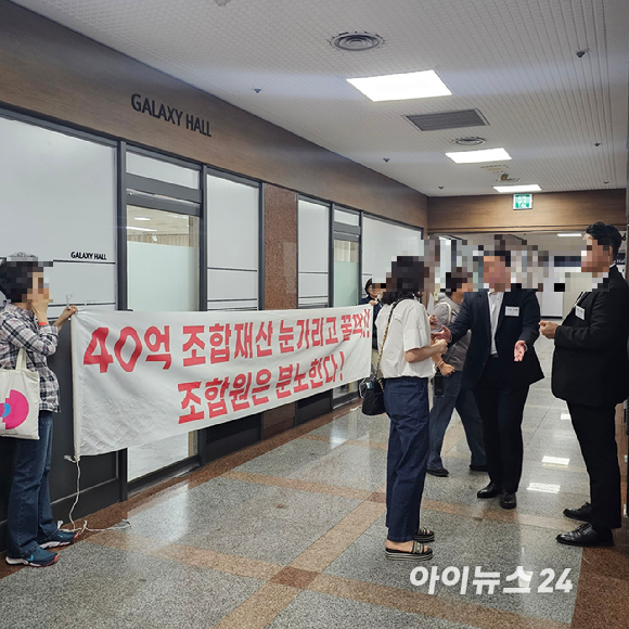 '래미안 블레스티지(개포주공2단지 재건축)' 청산 총회 현장 앞에 일부 조합원들이 '성과급 지급 안건'에 반대하며 현수막을 들고 서 있다. 다른 조합원들은 똑같은 현수막을 총회장 안에서도 들고 있다. 2025.09.29 [사진=이효정 기자 ]