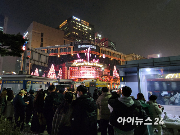 신세계백화점 본점 맞은편에서 시민들이 영상을 감상하고 있다. [사진=구서윤 기자]