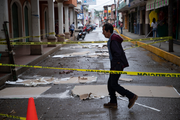 멕시코 미초아칸주 인근에서 규모 7.6의 강진이 발생한 지 하루 뒤인 20일(현지시간) 코알코만에서 한 주민이 봉쇄된 도로 사이를 건너고 있다. 이번 지진으로 최소 1명이 숨진 것으로 나타났으며 지난 1985년과 2017년에도 같은 날인 19일에 지진이 발생해 화제가 됐다. 1985년에는 규모 8.0의 지진이 발생해 최소 9천500명이, 2017년에는 규모 7.1의 지진으로 360명이 목숨을 잃었다. [사진=AP/뉴시스]