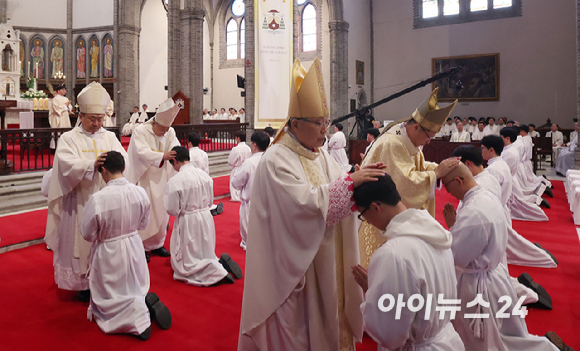 1일 서울 중구 명동대성당에서 열린 2024년 천주교 서울대교구 부제 서품식에서 부제 수품자들이 정순택 대주교를 비롯한 교구 주교·사제단에게 안수받고 있다. [사진=사진공동취재단]