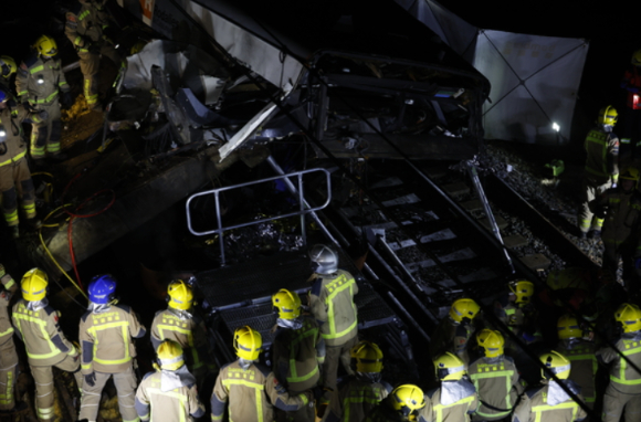 20일 스페인 바르셀로나의 겔리다 시에서 옹벽이 선로로 붕괴되며 열차가 사고를 당한 현장에서 소방대원들이 구조 작업을 벌이고 있다. [사진=EPA/연합뉴스]