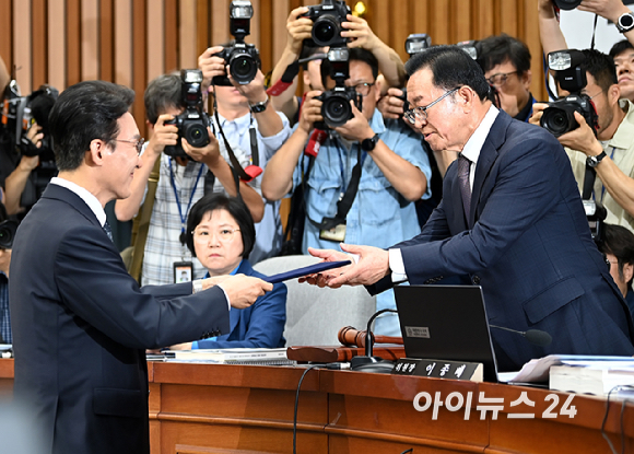 김민석 국무총리 후보자가 24일 서울 여의도 국회에서 열린 국무총리(김민석) 임명동의안 심사를 위한 인사청문회에서 이종배 위원장에게 선서문을 제출하고 있다. [사진=곽영래 기자]