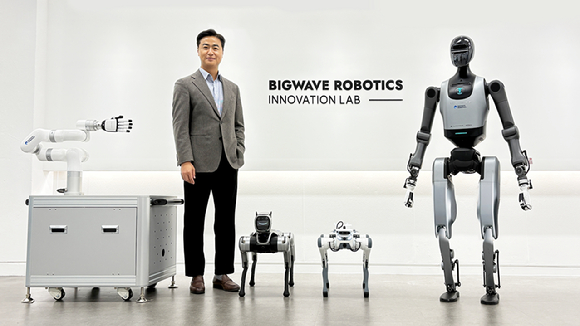 김민교 빅웨이브로보틱스 대표가 새롭게 문을 연 이노베이션 랩에서 휴머노이드 로봇을 포함한 주요 연구용 로봇과 함께 포즈를 취하고 있다. [사진=빅웨이브로보틱스]