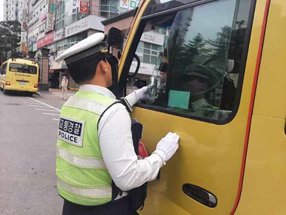 지난 17일 파주경찰서 소속 교통경찰관이 어린이 통학차량 운전자를 대상으로 법규위반 행위를 단속하고 있다. [사진=파주경찰서]