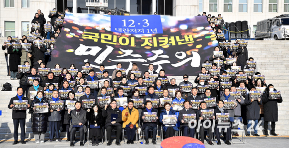 더불어민주당 정청래 대표와 김병기 원내대표, 의원들과 시민들이 3일 서울 여의도 국회 본관 앞 계단에서 열린 12.3 내란 저지 1년 현장 최고위원회의에서 기념촬영을 하고 있다. [사진=곽영래 기자]