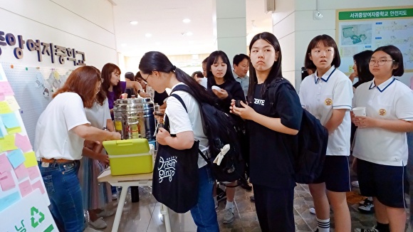 서귀중앙여자중학교의 학부모 환경 동아리 '잇다'가 학생들이 미리 준비해 온 텀블러에 아이스티를 담아 주고 있다.  [사진=서귀포중앙여자중학교]