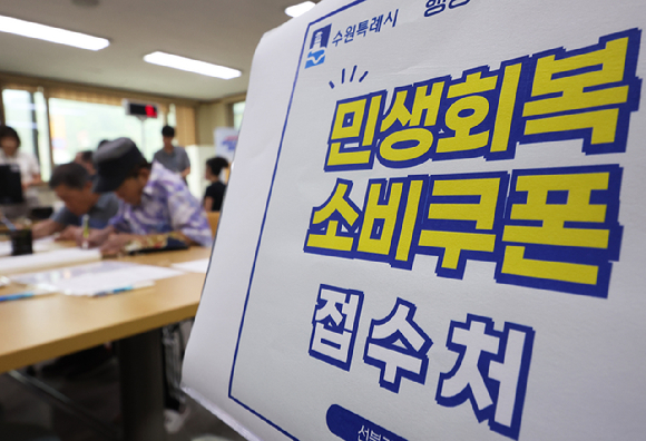 민생회복 소비쿠폰 1차 신청 첫날일 21일 인천 미추홀구 숭의1·3동 행정복지센터에서 한 시민이 신청한 선불카드를 받고 있다. [사진=연합뉴스]