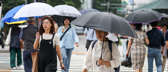 서울 중구 청계광장 인근에서 우산을 쓴 시민들이 이동하고 있다. [사진=뉴시스]