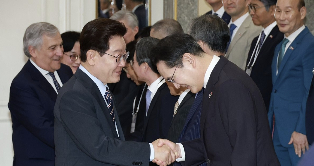 이재명 대통령이 지난 12일(현지시간) 이탈리아 로마의 한 호텔에서 열린 비즈니스 라운드테이블에 입장하며 이재용 삼성전자 회장과 악수하고 있다. [사진=연합뉴스]