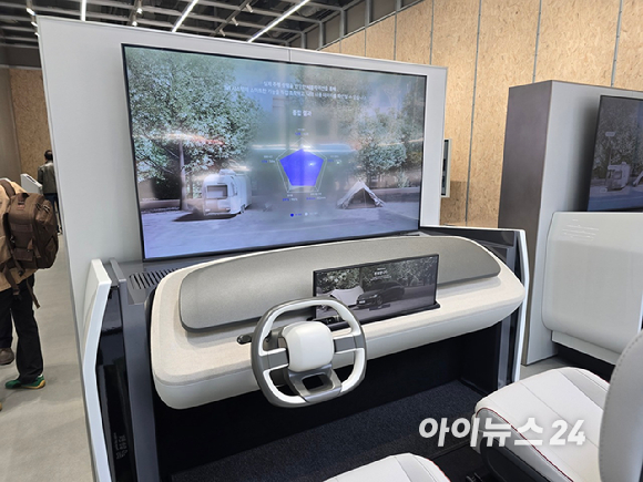 '플레오스 커넥트' 대화면 디스플레이. 왼쪽 '주행 정보 화면'에 주변의 객체와 차선 정보를 인식하는 모습이 표시되고 있다. 오른쪽 '앱 화면'은 내비게이션과 블루투스 오디오가 분할 화면으로 실행되고 있다. [사진=현대자동차그룹]