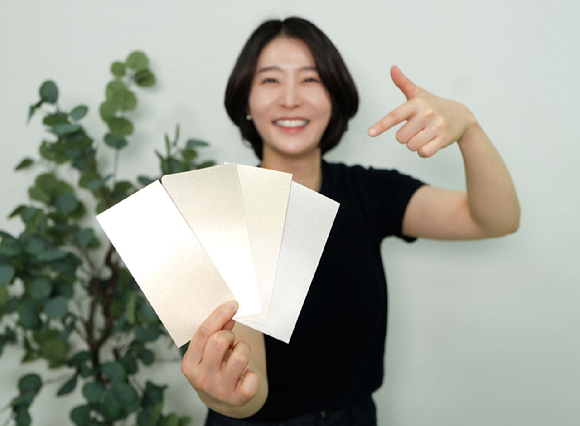 KCC 관계자가 실제 금속(왼쪽 두번째)과 숲으로메탈릭을 칠한 종이(그 외 3개)를 비교하고 있다. [사진=KCC]