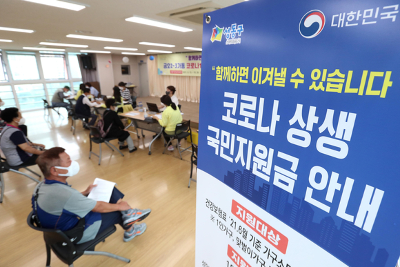 서울 성동구 금호2-3가동 주민센터에서 직원들이 코로나 상생 국민지원금 접수를 받고 있다. [사진=뉴시스]