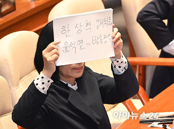 최민희 국회 과학기술정보방송통신 위원장이 18일 서울 여의도 국회에서 열린 본회의에서 이진숙 방송통신위원장에 대한 교육&middot;사회&middot;문화에 관한 질문 중 '한상혁 강제퇴출, 윤석열 방송장악' 이라고 쓴 손팻말을 들어 보이고 있다. [사진=곽영래 기자]