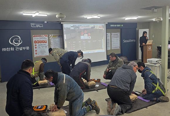 6일 한화 건설부문이 서울아레나 복합문화시설현장에서 진행한 안전교육에서 외국인 노동자들이 상황에 맞춰 자동심장충격기(AED)를 사용하고 있다. [사진=한화 건설부문]