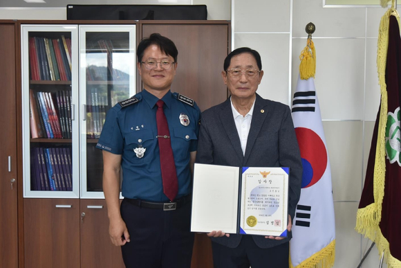 심명섭 속초경찰서장으로부터 감사장을 받는 학교배움터지킴이 오신호씨(오른쪽) [사진=속초경찰서]