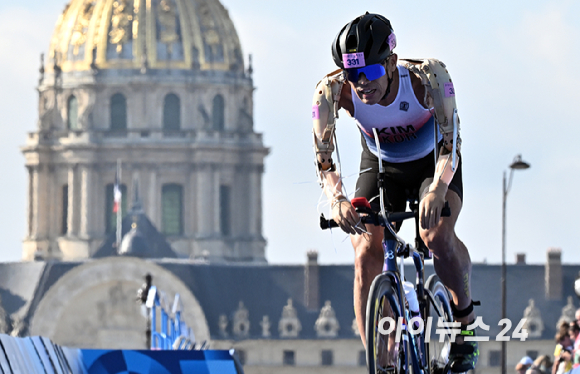 김황태가 2일(현지시간) 프랑스 파리 알렉상드로 3세 다리 인근에서 열린 2024 파리 패럴림픽 남자 트라이애슬론(철인 3종) PTS3 등급 경기에서 앵발리드를 배경으로 사이클을 타고 있다. [사진=사진공동취재단]