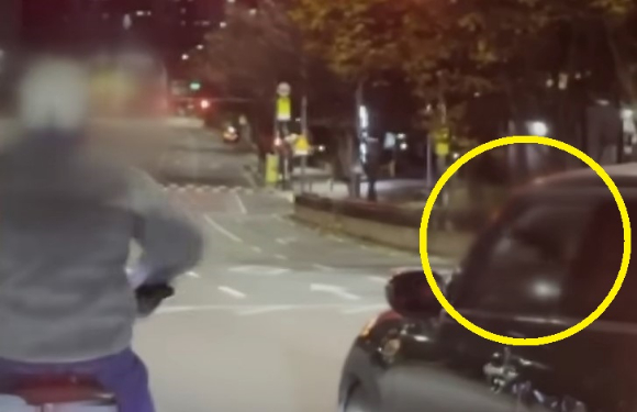 오토바이 운전자와 다툼 중 총으로 보이는 물체를 꺼내 창 밖으로 흔든 운전자가 영상에 포착됐다. [사진=JTBC '사건반장' 캡처]