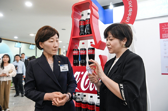 한화진 환경부 장관이 5일 용인 포은아트홀에서 진행된 ‘제29회 환경의 날 기념식’을 찾아 코카-콜라의 전시 부스에서 ‘보틀투보틀’ 방식을 적용해 생산된 ‘코카-콜라 재생 보틀’을 살펴보고 있다. 코카-콜라는 지난해 환경부와 식약처의 제도 개선을 통해 국내에서도 물리적 재생원료를 식품용기에 사용할 수 있게 됨에 따라 재생원료 10%를 포함한 재생페트 제품 ‘코카-콜라 재생 보틀’을 선보였다. 이날 코카-콜라는 국내 재생물질 활성화 및 투명 페트병 순환구축에 기여한 노력을 인정받아 대통령상을 수상했다. [사진=코카-콜라사]