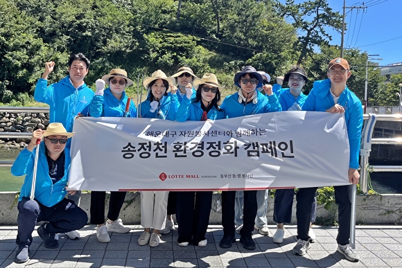 롯데몰 동부산점 봉사단원들이 지난 30일 부산광역시 해운대구청 자원봉사센터 단원들과 함께 송정천 주변 쓰레기와 폐비닐 수거 작업 등 정화 활동을 한 뒤 기념촬영을 하고 있다. [사진=롯데쇼핑]