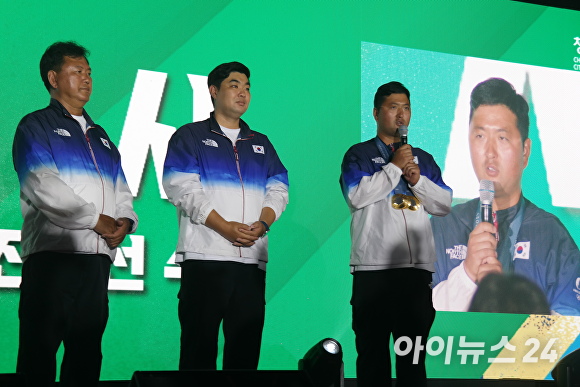 김우진 선수(오른쪽)가 8일 청주동부창고 6동에서 열린 ‘2024 파리올림픽 남자 양궁 3관왕 기념 선수단 환영식’에서 답사를 하고 있다. [사진=임양규 기자]