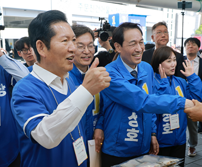 더불어민주당 정청래 총괄상임선거대책위원장이 22일 민주당 우상호 강원도지사 후보&middot;김중남 강릉시장 후보와 강원 강릉시 주문진시장을 방문해 상인과 인사하고 있다. 2026.5.22 [사진=연합뉴스]