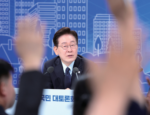 이재명 대통령이 지난달 23일 서울 여의도 KBS 별관에서 열린 부동산 정책 국민 대토론회에서 발언권을 요청하는 참석자들을 바라보고 있다. [사진=연합뉴스]