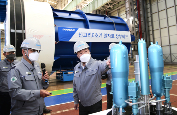 박정원 두산그룹 회장이 지난 15일 경남 창원 두산에너빌리티 원자력 공장 내 원자로 헤드 앞에서 원전 모형을 보며 사업 현황을 점검하고 있다. [사진=두산그룹]