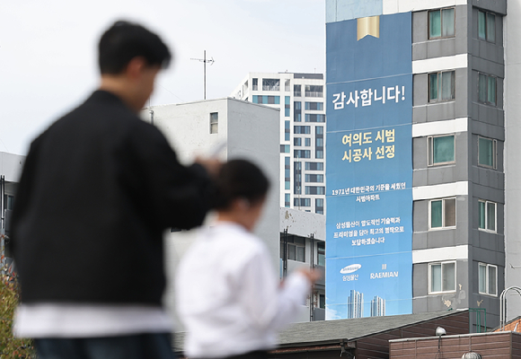 19일 서울 영등포구 여의도 시범아파트 단지에 재건축 시공사 선정 관련 대형 현수막이 걸려 있다. [사진=연합뉴스]