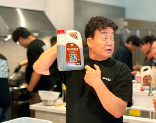 美 식품 유통기업 JFC&middot;위즈메탁 주요 관계자를 대상으로 TBK 소스를 소개하고 요리를 시연 중인 백종원 대표. [사진=더본코리아]