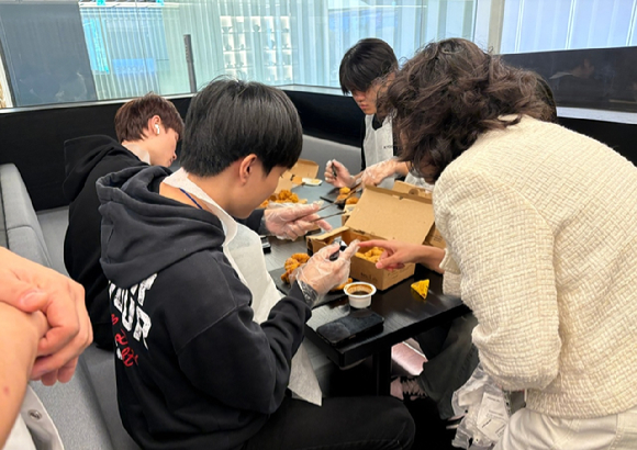 지난 23일 교촌에프앤비 판교 본사에서 진행된 기업탐방 프로그램에 참여한 이주배경 청소년들이 교촌치킨을 조리하고 있다. [사진=교촌에프앤비]