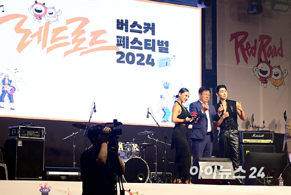 29일 오후 서울 홍대 레드로드에서 열린 '레드로드 버스커 페스티벌 2024'에서 스포츠댄스팀 이즈백이 우수상을 받고 박강수 마포구청장과 기념촬영을 하고 있다. [사진=정소희 기자]