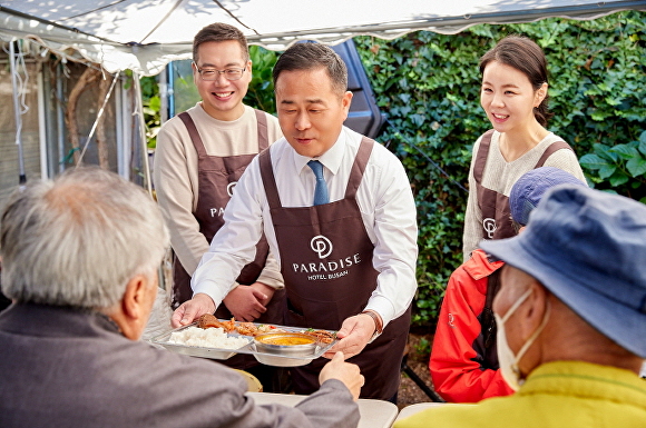 윤진상 파라다이스 호텔 부산 총지배인(가운데)이 지난 7일 부산광역시 해운대구 우동에서 진행된 무료 배식 봉사활동에 참여하고 있다. [사진=파라다이스 호텔 부산]