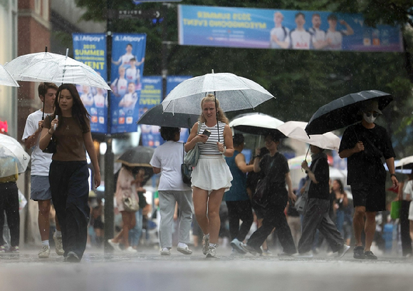 비가 내리는 서울 명동 거리에 외국인 관광객들이 우산을 쓴 채 걸어가고 있다. [사진=연합뉴스]