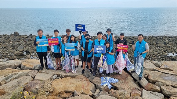 현대제철 당진제철소 가족봉사단이 당진 석문방조제 전역을 대상으로 환경 정화활동을 한 뒤 기념촬영을 하고 있다. [사진=현대제철]